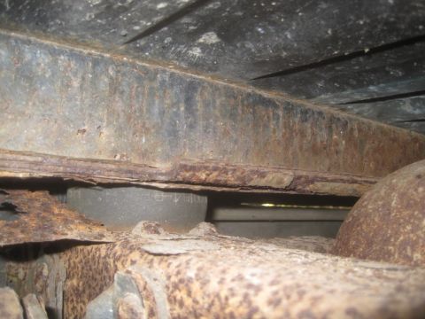 1993 Ford Bronco - Close-up view of heavily rusted undercarriage components, indicating significant wear and potential structural compromise.