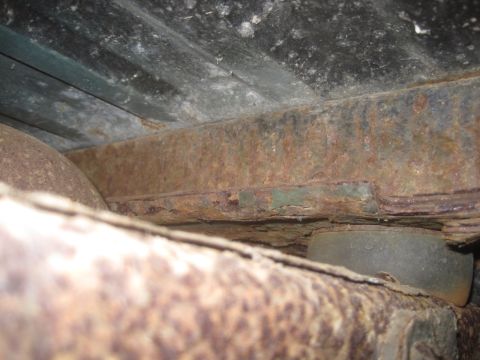 1993 Ford Bronco - The undercarriage of a vehicle shows significant rust on its frame and components, with a Supermotors logo visible at the bottom right.