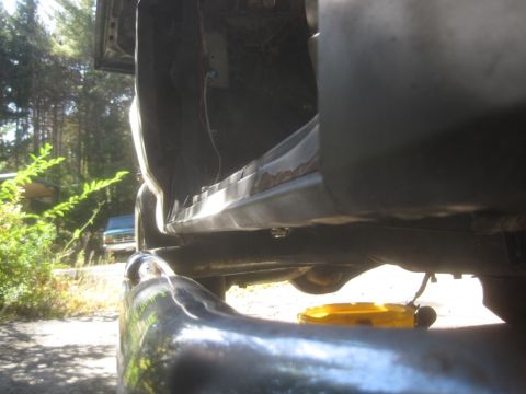 1993 Ford Bronco - Vehicle rocker panel and interior detail with oil drain pan visible below.