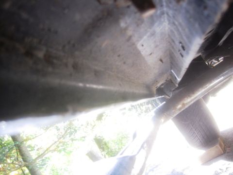 1993 Ford Bronco - Close-up of the underside of a vehicle, revealing structural components and a tire.