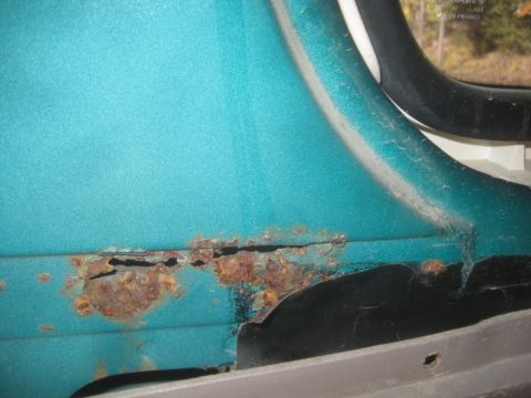 1993 Ford Bronco - This close-up shows extensive rust on a teal body panel, indicating potential structural issues.