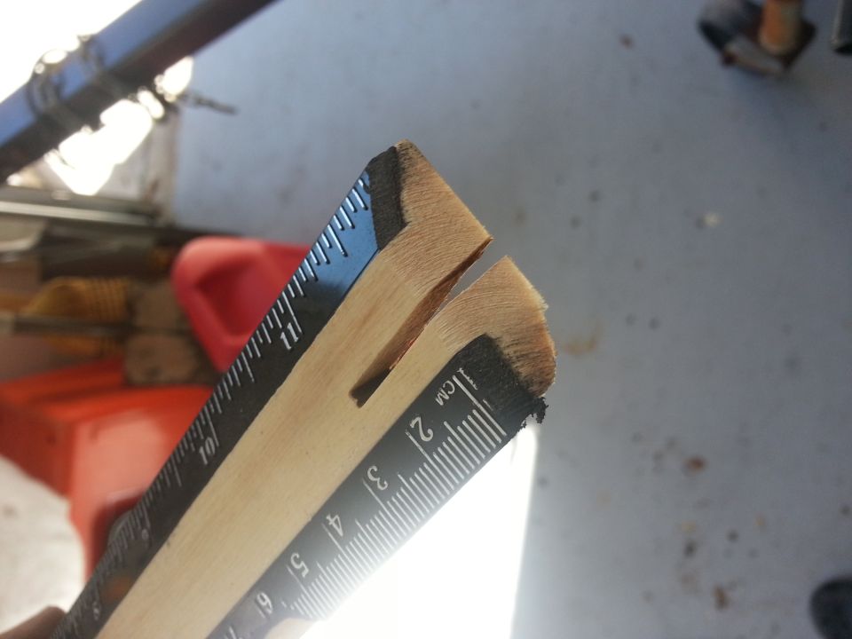 Wooden ruler with black markings showing centimeters and inches, split at the end