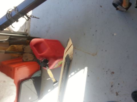 1994 Ford Bronco - A close-up view of a vehicle brake part, with other items like a gas can and brooms visible in the background.