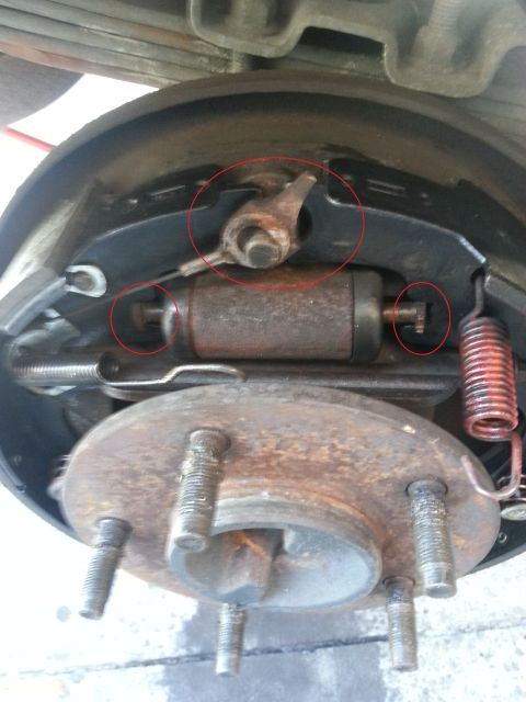 1994 Ford Bronco - Close-up view of a vehicle's rear drum brake assembly, with key parts highlighted by red circles.