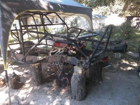 1986 Ford Bronco - Custom buggy chassis and engine assembly undergoing work outdoors.