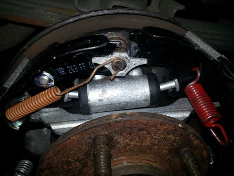 1994 Ford Bronco - A close-up view of a vehicle's rear drum brake system, showing the brake shoes and springs.