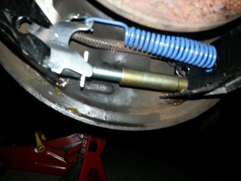 1994 Ford Bronco - Close-up of a vehicle's drum brake assembly, showing internal components and a red jack stand.
