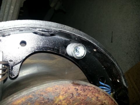 1994 Ford Bronco - A close-up view of a rear drum brake assembly, highlighting the adjuster screw mechanism.