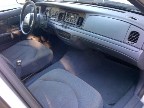 2001 Ford Crown Victoria - The interior of a 2001 Ford Crown Victoria is shown from the passenger side, looking towards the driver's seat and dashboard.