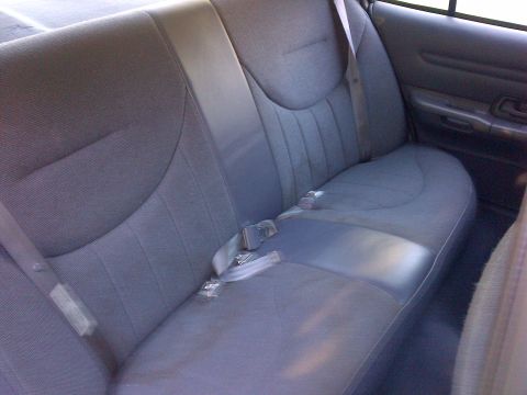 2001 Ford Crown Victoria - Interior view of a gray fabric rear seat with seatbelts and a door panel.