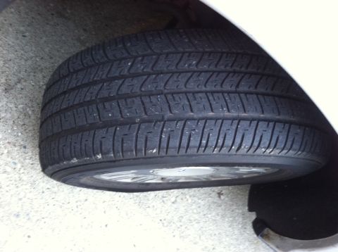 2001 Ford Crown Victoria - A close-up view of a vehicle's tire and wheel assembly.