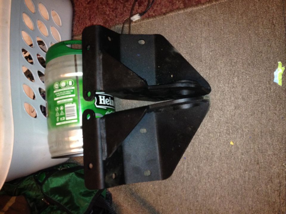 Two black metal truck suspension brackets next to a Heineken keg and a laundry basket