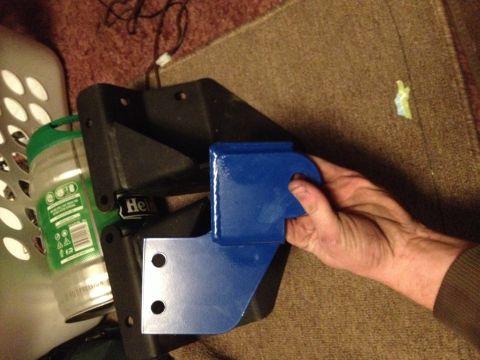 1995 Ford F-150 - A blue metal part is being held, with a black bracket and a can visible in the background.