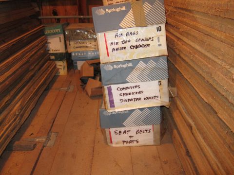 1991 Ford LTD Crown Victoria - Photograph of storage boxes with handwritten part labels in a wooden shed, not a technical document.