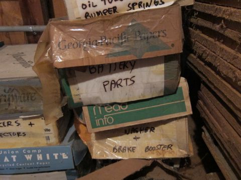 1991 Ford LTD Crown Victoria - Boxes labeled with various car parts are stacked in storage.