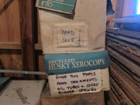 1991 Ford LTD Crown Victoria - A collection of boxes are stored, with labels indicating yard sale items and car parts.