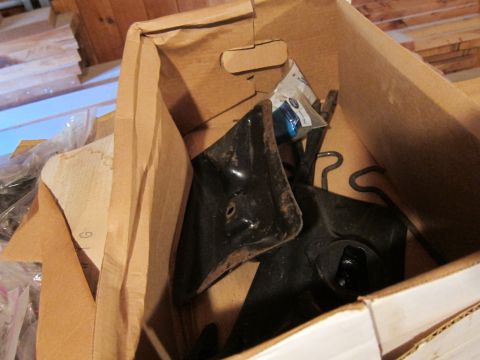 1991 Ford LTD Crown Victoria - Cardboard box containing various black metal automotive parts.