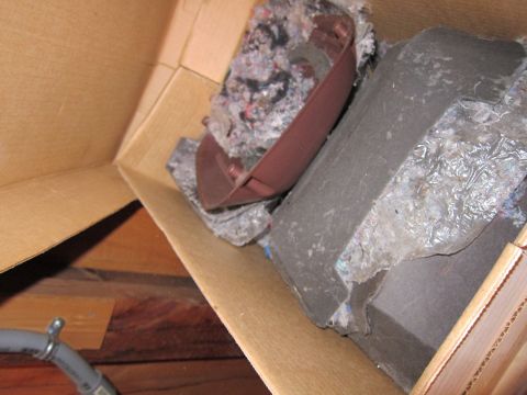 1991 Ford LTD Crown Victoria - A brown plastic interior trim piece and insulation are visible inside a cardboard box.