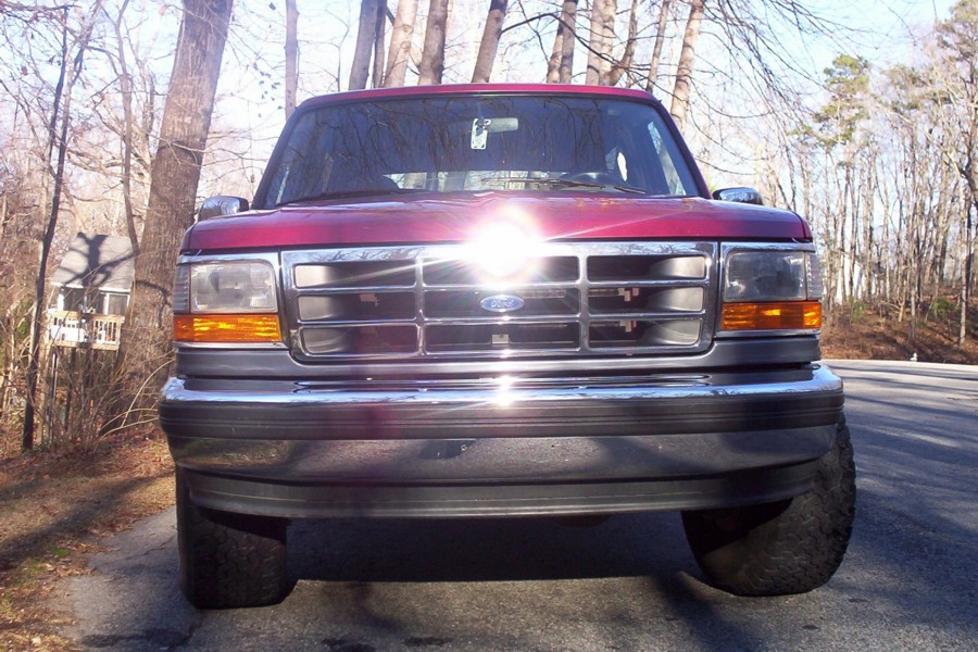 Red 1995 Ford Bronco front view with chrome grille and bumper