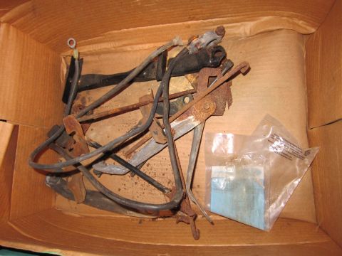 1991 Ford LTD Crown Victoria - A collection of assorted, aged automotive components are stored within a cardboard container.