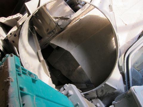 1991 Ford LTD Crown Victoria - Debris and damaged vehicle components are piled together in what appears to be a junkyard or scrap area.