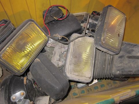 1991 Ford LTD Crown Victoria - Assorted car headlights piled together, some with yellow lenses and visible wiring.