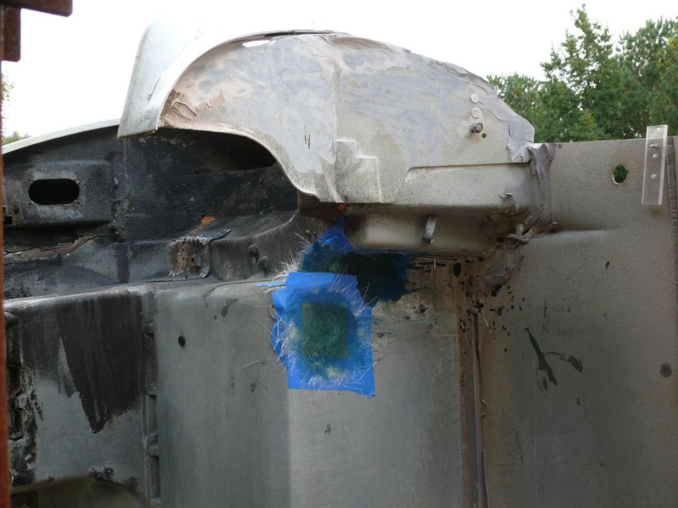 car frame with blue tape and fiberglass patch on wheel well area