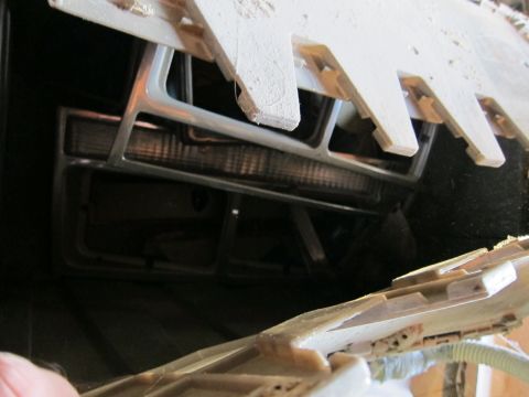 1991 Ford LTD Crown Victoria - The front grille and headlight assembly of a vehicle are visible, with wooden planks overhead.