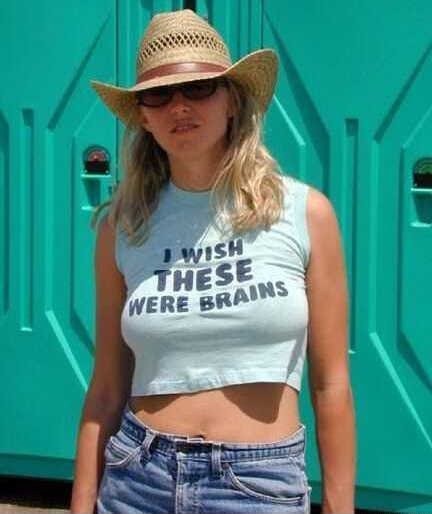 2006 Ford E350 - A woman stands in front of a teal portable toilet, wearing a straw hat and a crop top with text.