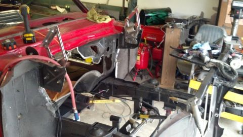 1964 Ford Fairlane - Car body in a workshop, likely undergoing restoration or repair, with various tools and equipment visible.