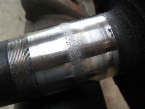 1994 Ford Bronco - Close-up of a worn metal shaft with visible scoring and threaded sections.