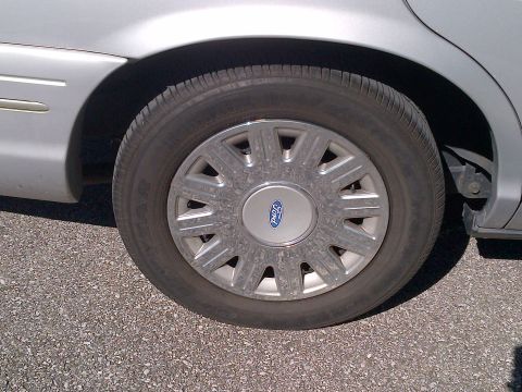2001 Ford Crown Victoria - Close-up of a silver 2001 Ford Crown Victoria wheel the iconic Ford logo on the hubcap.