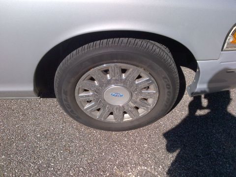 2001 Ford Crown Victoria - The front wheel and fender of a silver Ford Crown Victoria are shown in this close-up shot.