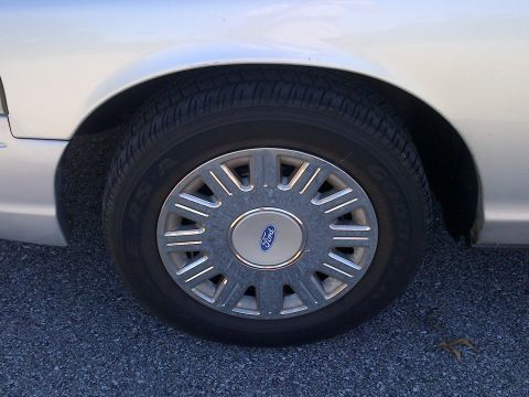 2001 Ford Crown Victoria - Close-up of a silver Ford Crown Victoria's front wheel and fender.