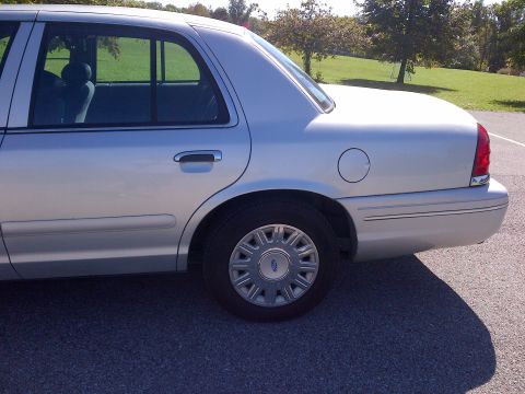 2001 Ford Crown Victoria - Rear view of a silver 2001 Ford Crown Victoria, showing its distinctive body style and wheel design.