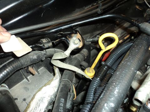 2004 Mercury Grand Marquis - Close-up view of an engine bay, focusing on a yellow oil dipstick and various hoses and wiring.