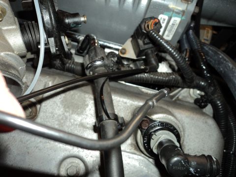 2004 Mercury Grand Marquis - Engine bay detail with fuel lines and sensors, a wrench is on a fitting.