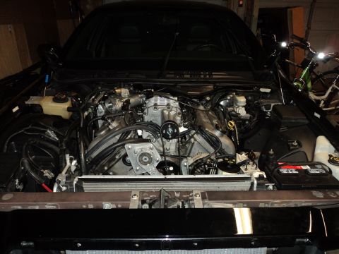 2004 Mercury Grand Marquis - Engine bay view of a supercharger installation in a black car. The registry claims it is a 2004 Mercury Grand Marquis, but this is unconfir…