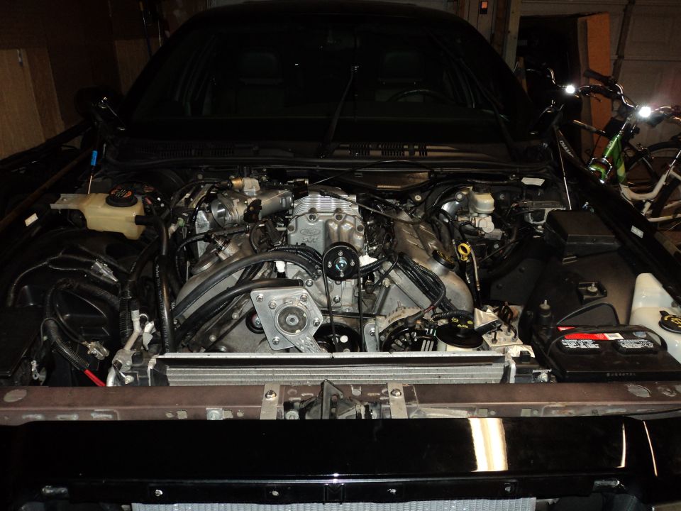 Engine bay with supercharger installed. Black car