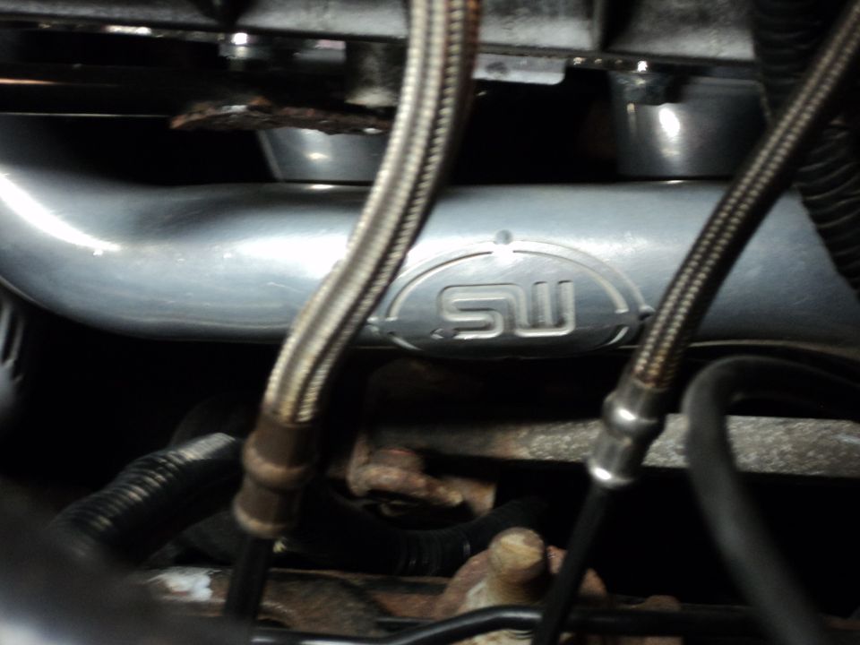 Engine component with SW logo and braided metal hoses