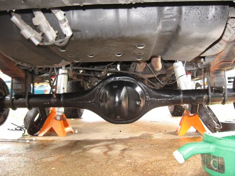 1994 Ford Bronco - The rear axle assembly of a vehicle is shown supported by jack stands during maintenance.