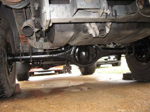 1994 Ford Bronco - Underside view of a vehicle's rear differential and axle assembly, with other vehicles visible in the background.