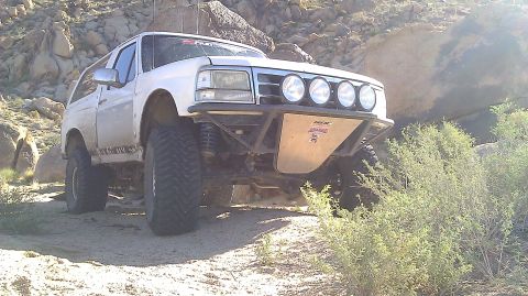 1996 Ford Bronco - Modified 1996 Ford Bronco parked on a dirt trail in a rocky, desert-like environment.