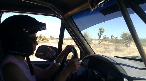 1996 Ford Bronco - A person wearing a helmet drives through a desert landscape with Joshua trees.