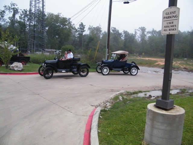 Two black 1909 Ford Model Ts driving on a road