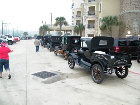 1909 Ford Model T - Several vintage Ford Model T vehicles are parked in a row outside a hotel.
