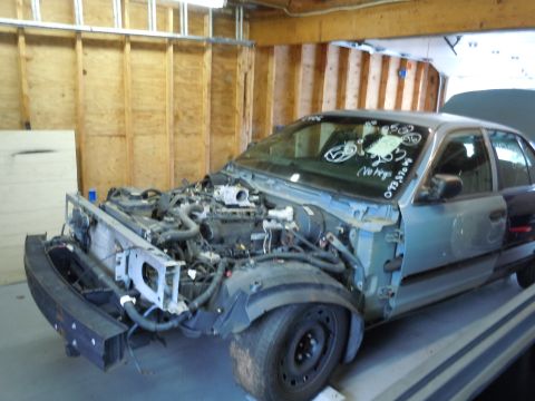 2001 Ford Crown Victoria - The front end of a 2001 Ford Crown Victoria is disassembled, revealing the engine and internal components.