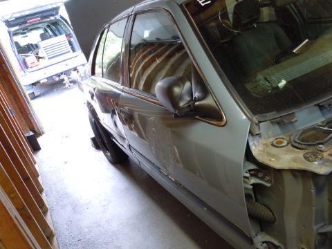 2001 Ford Crown Victoria - A 2001 Ford Crown Victoria is seen from the side in a garage, with another vehicle in the background.