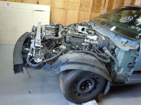 2001 Ford Crown Victoria - The front end of a car is dismantled, exposing the engine and associated components. The fender is missing, and the hood is ajar.