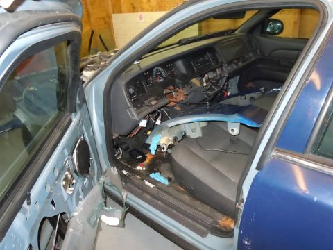 2001 Ford Crown Victoria - The interior of a 2001 Ford Crown Victoria is visible with the dashboard disassembled and wiring exposed.